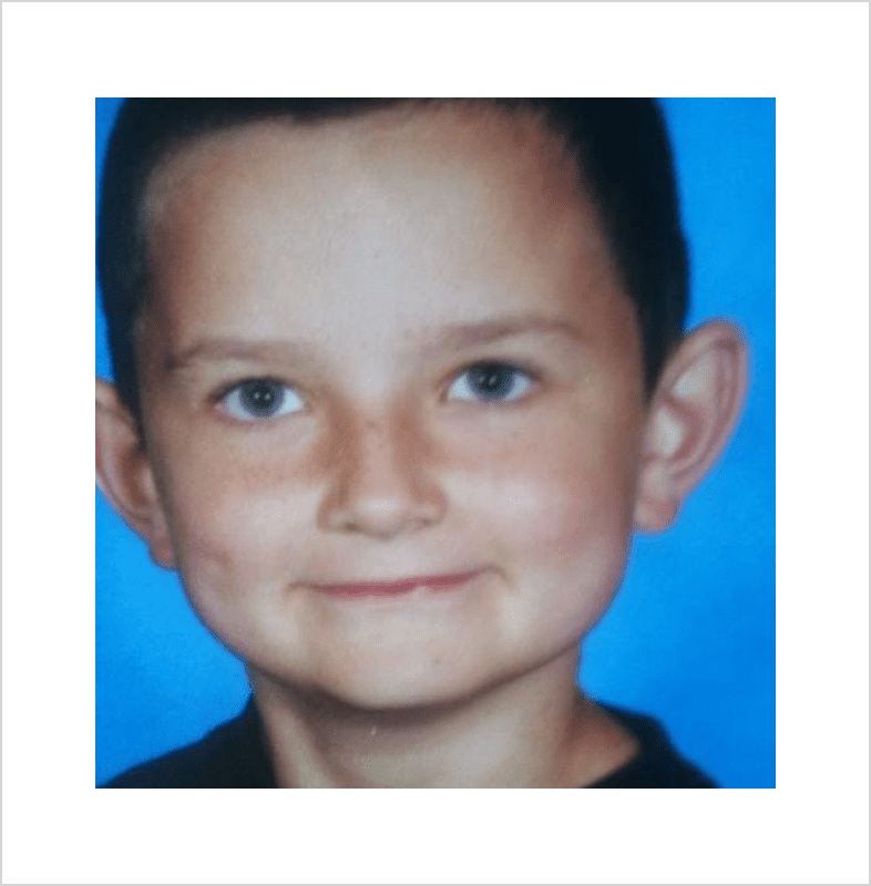 Child with short hair, blue backdrop