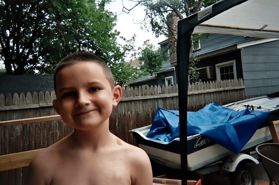 Happy child outdoors near fence