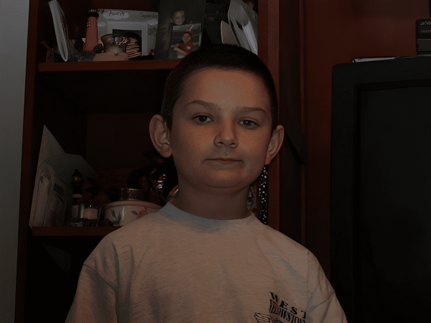 Boy standing in front of shelves